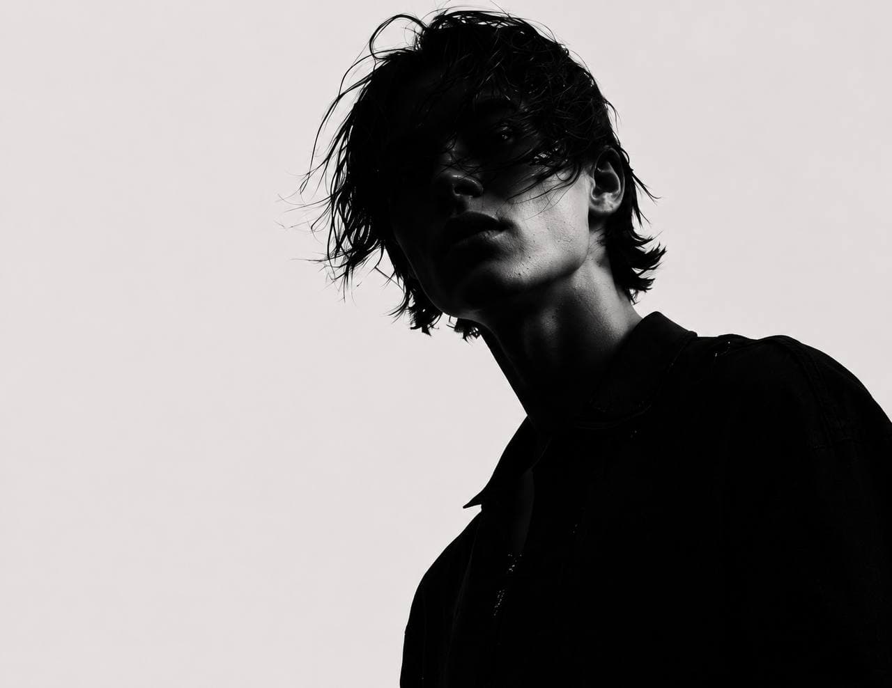 Silhouette of a person against a pale background, black and white