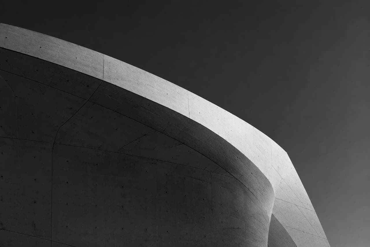 Curved concrete facade catching a single band of light