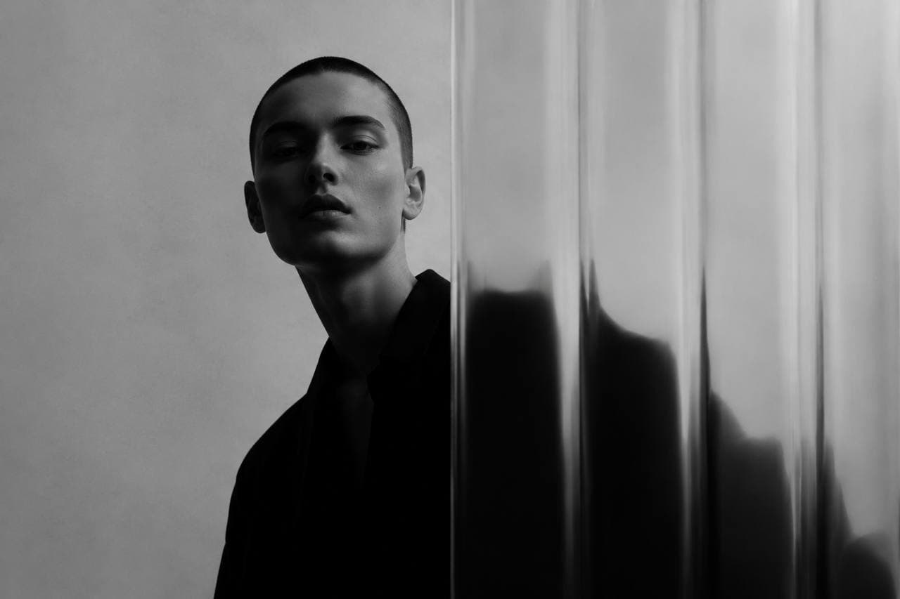Portrait half hidden behind rippled glass, black and white