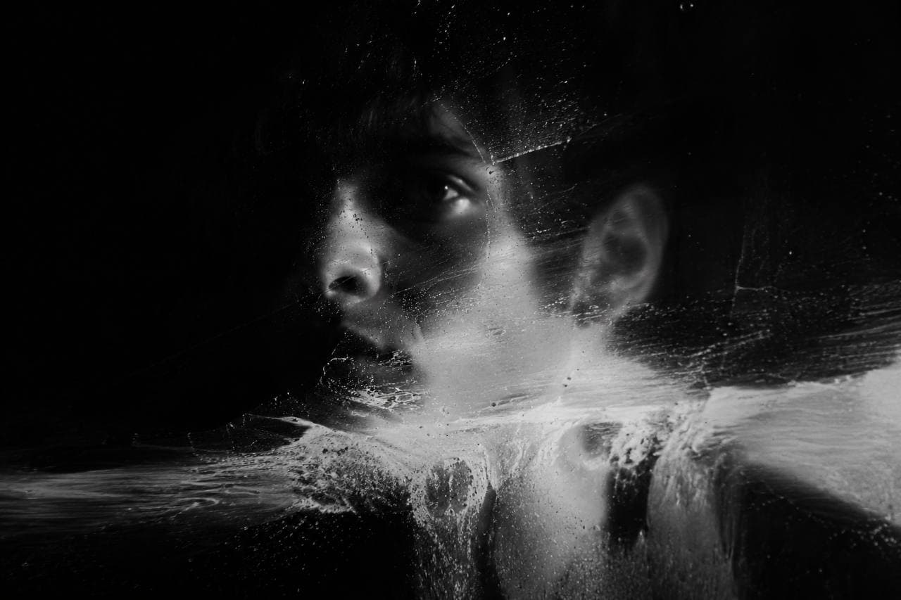 Face seen through water and reflections, black and white